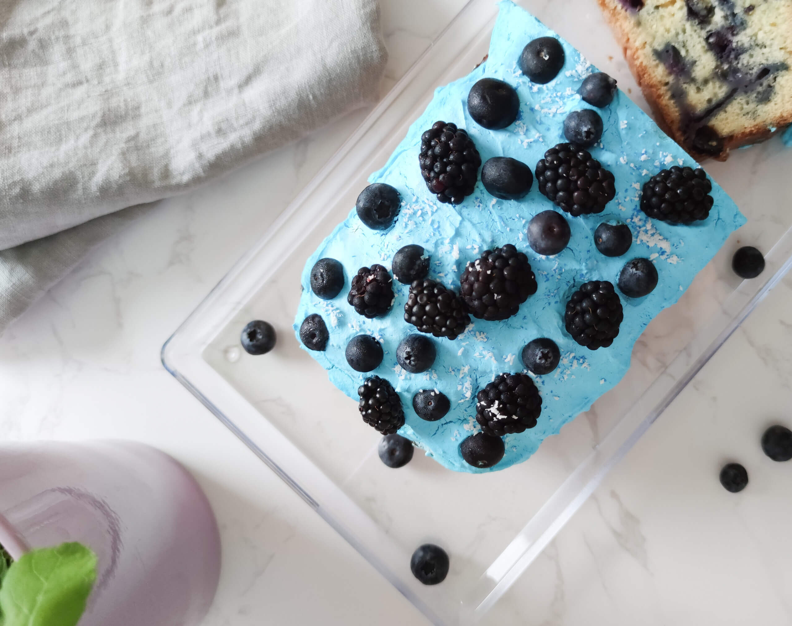 Veganer Blaubeerkuchen garniert mit Blaubeeren und Brombeeren.