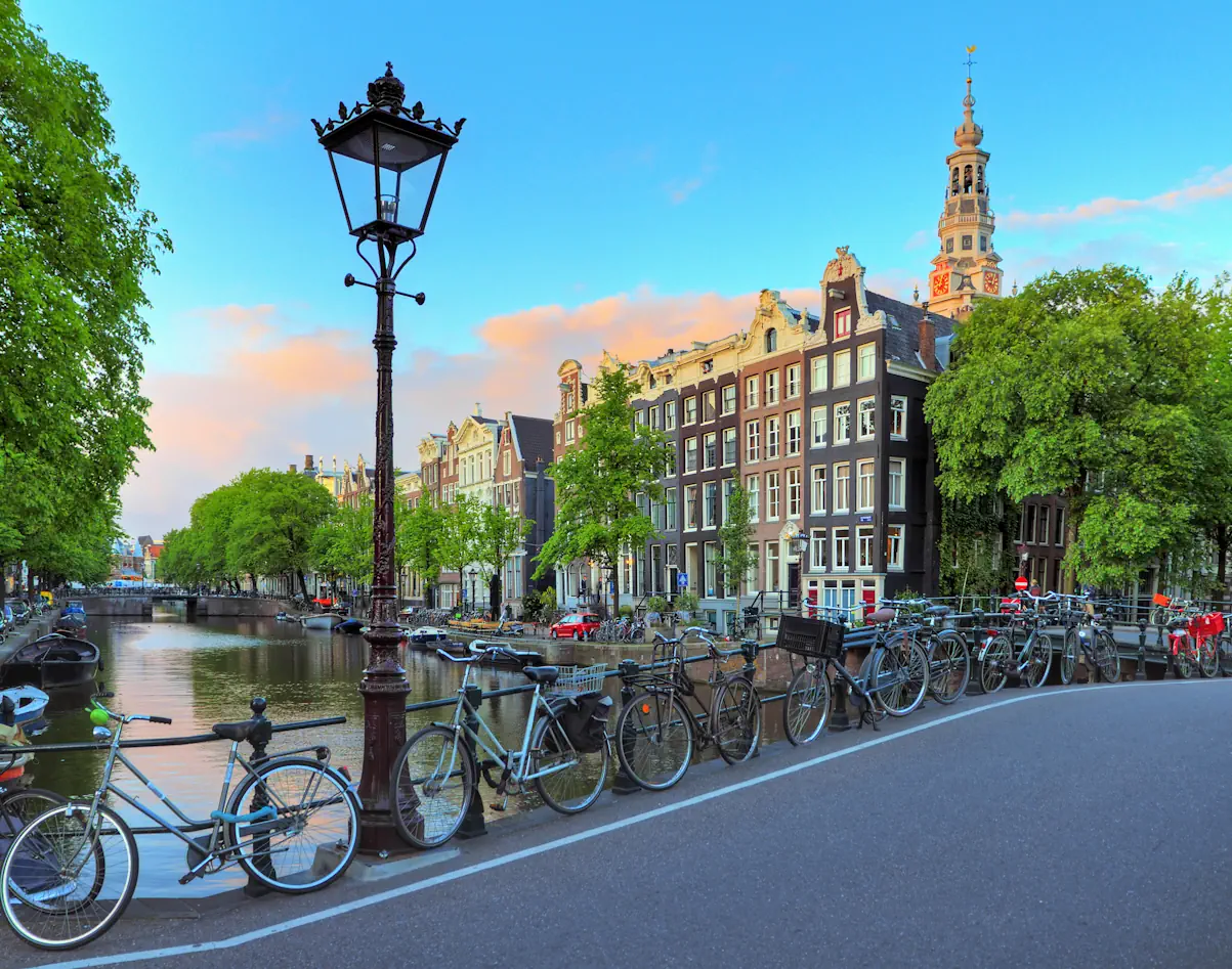 Viele Fahrräder auf einer Brücke in Amsterdam mit Blick auf die Grachten.