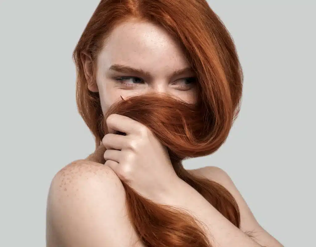 Frau mit roten langen Haaren und Sommersprossen