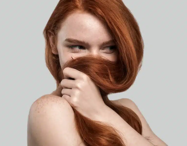 Frau mit roten langen Haaren und Sommersprossen